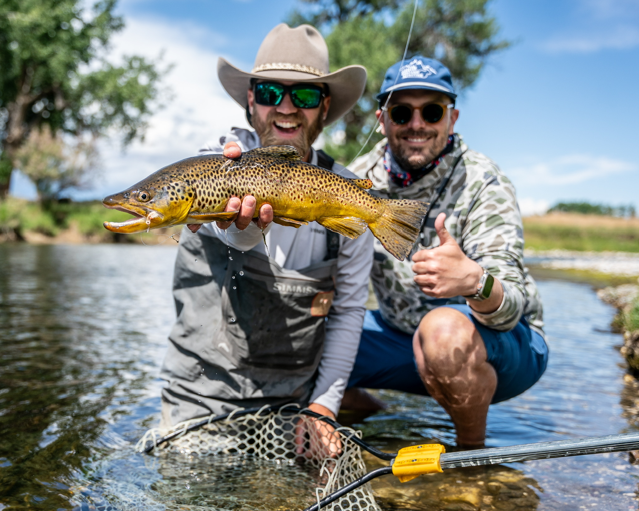 Anglers holding a brown trout on the Bighorn River, Montana